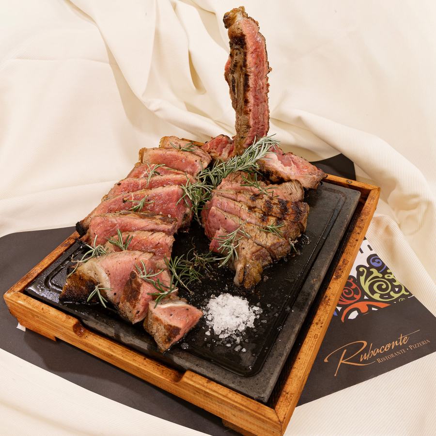 Bistecca alla fiorentina servita sulla pietra rovente con rosmarino e sale grosso