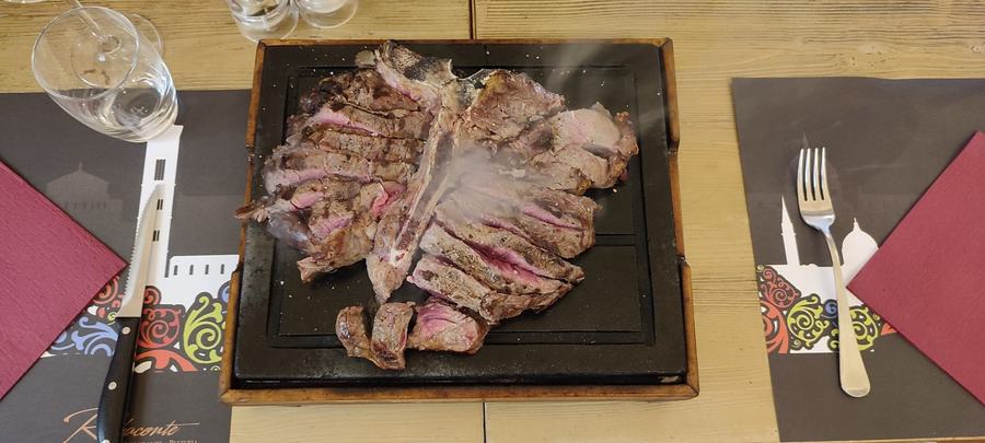 Bistecca tagliata e ancora fumante portata al tavolo sulla pietra