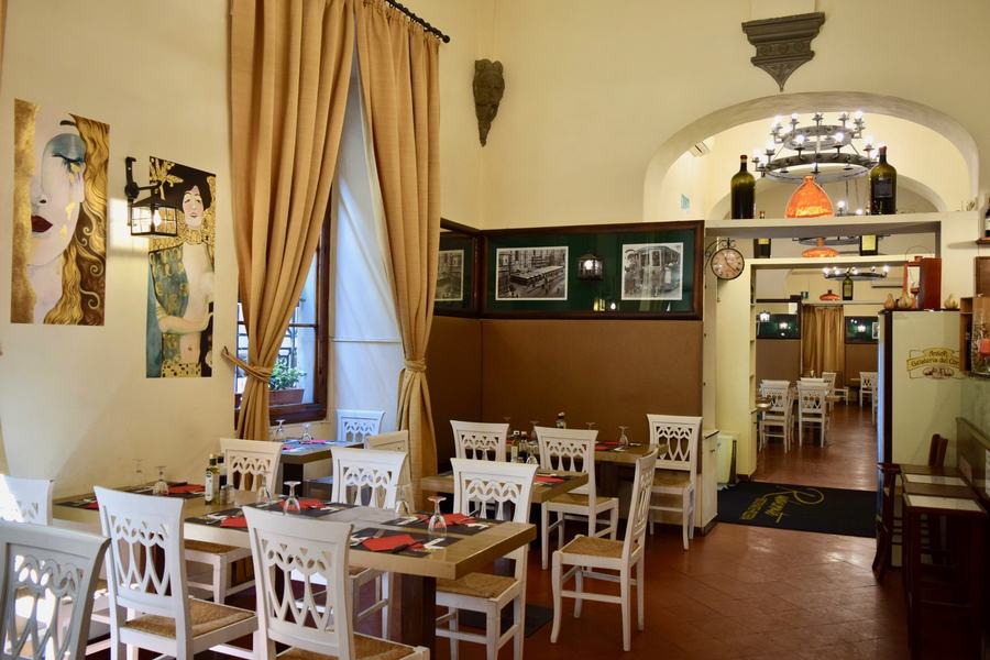 Sala interna con tavoli quadrati ravvicinati e luce calda